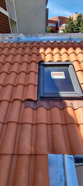 Spécialiste de la pose de fenêtre de toit de chez velux a Toulouse sur une couverture en tuile mécanique  y compris habillage des acrotère en zinc par les 2 charpentiers.