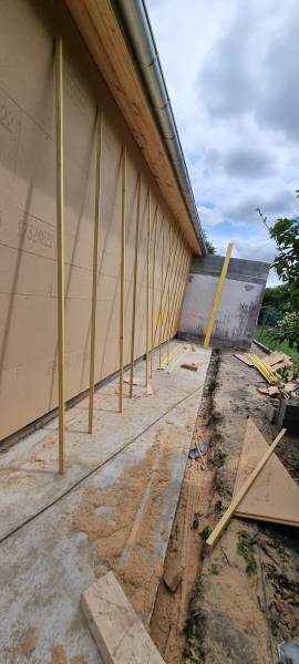 Isolation par l'intérieur  en panneaux fibre de bois rigide sur ossature bois avant la pose de pare pluie par les 2 charpentiers a Ramonville 