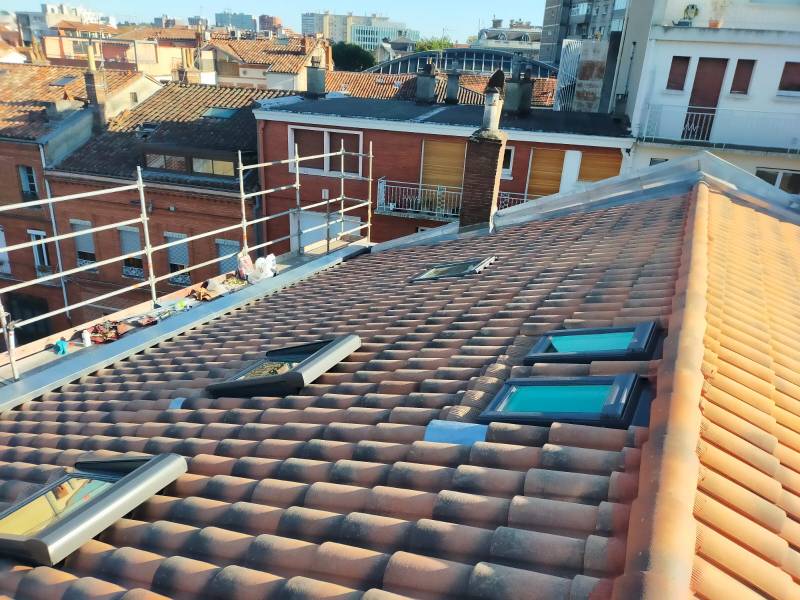 Rénovation de la tuile mécanique et pose de fenêtre de toit de chez vélux a Toulouse . les 2 charpentiers. 