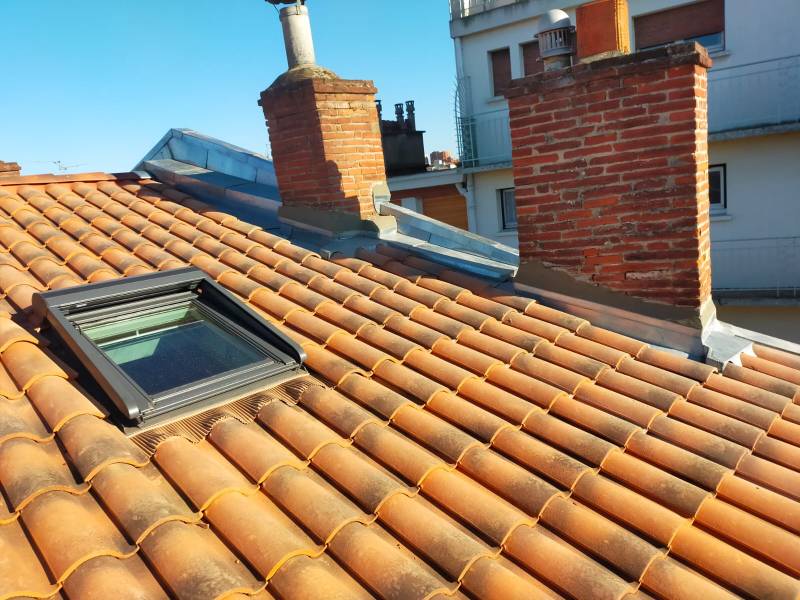 Pose d'un velux et renovation de la couverture en tuile en centre ville de Toulouse. Les 2 charpentiers 