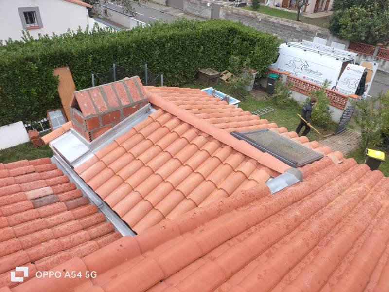 Raccord de la toiture en tuileDC12 avec un cheneau en zinc, un entourage de cheminée sur mesure et de la tuile DC12 a Toulouse et a Albi par les 2 charpentiers. 