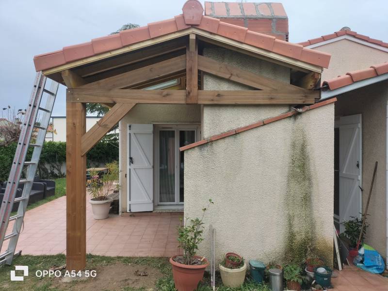 Vue de notre création de la terrasse couverte en tuile et en charpente traditionnelle par les 2 charpentiers, artisan charpentiers couvreur zingueur 