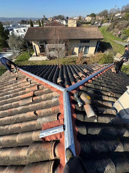 Pose de closoir rigide en plomb long de deux mètres pour réfection  du faitage et des arteiers en tuile a Toulouse et a Albi par les 2 charpentiers.  