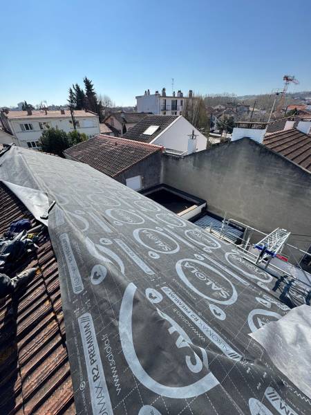 Pose de l'ecran sous toiture avant la couverture en tuile par les 2 charpentiers, proche d'Albi 