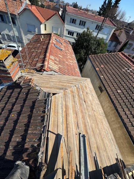 Dépose de l'ancienne couverture en tuile, avant la pose de la nouvelle tuile a Albi par les 2 charpentiers. 
