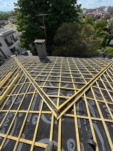 Pose d'un écran sous toiture et des liteaux pour le support de couverture en tuile a Albi par les 2 charpentiers.  
