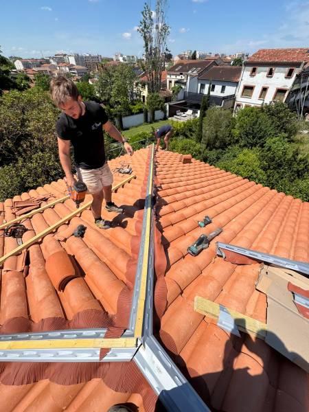 Pose des faitières d'arêtiers pour l'étanchéité , la finition et la ventilation de la toiture par les 2 charpentiers a Albi. 