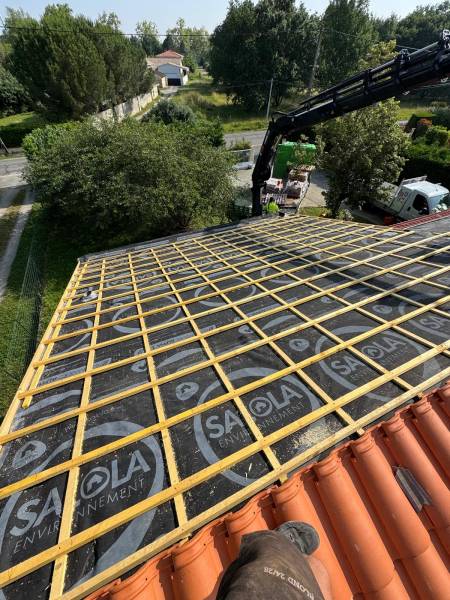 Pose en cour de la couverture en tuile mécanique DC12, par les 2 charpentiers, artisan couvreur a Albi. 