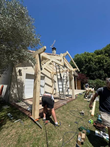 Levage en cour de la terrasse couverte en charpente traditionnelle a Albi par les 2 charpentiers.