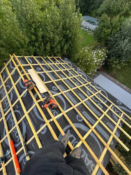 Mise en place de nouveaux chevron , d'un ecran sous toiture et des liteaux pour la nouvelle couverture en tuile a Albi par les 2 charpentiers. 