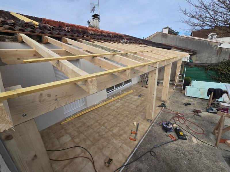 Levage de la structure de la charpente traditionnelle pour la terrasse couverte a Albi par les 2 charpentiers. 