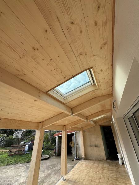 Vue de la terrasse couverte en charpente traditionnelle avec une sous face en volige mi bois rabotée , ainsi que la pose de le fenêtre de toit velux a Albi par les 2 charpentiers.