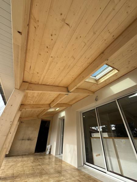 Fourniture et pose d'une sous face en volige mi bois rabotée et des fenêtres de toit velux sur la terrasse en charpente traditionnelle sur poteau bois par les 2 charpentiers a Albi. 