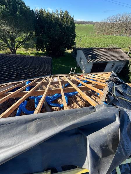 Mise en place de l'écran sous toiture après avoir déposé la vielle tuile, par les 2 charpentiers a Roquesérière. 