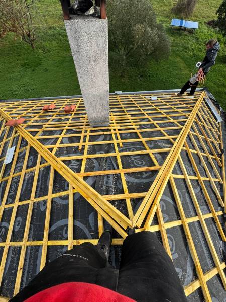Vue de la pose des lilteaux au niveau des raccord des arêtiers par les 2 charpentiers a Roquesérière, proche d'Albi.
