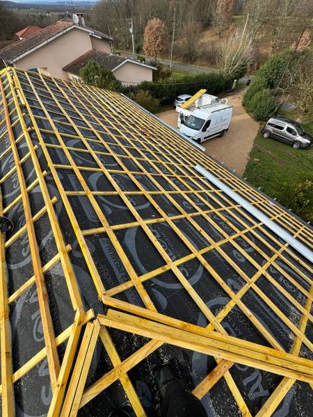 Mise en place de l'écran sous toiture, des contre lattes pour la ventilation et des liteaux pour le support de la couverture en tuile par les 2 charpentiers, a Roquesérière. 